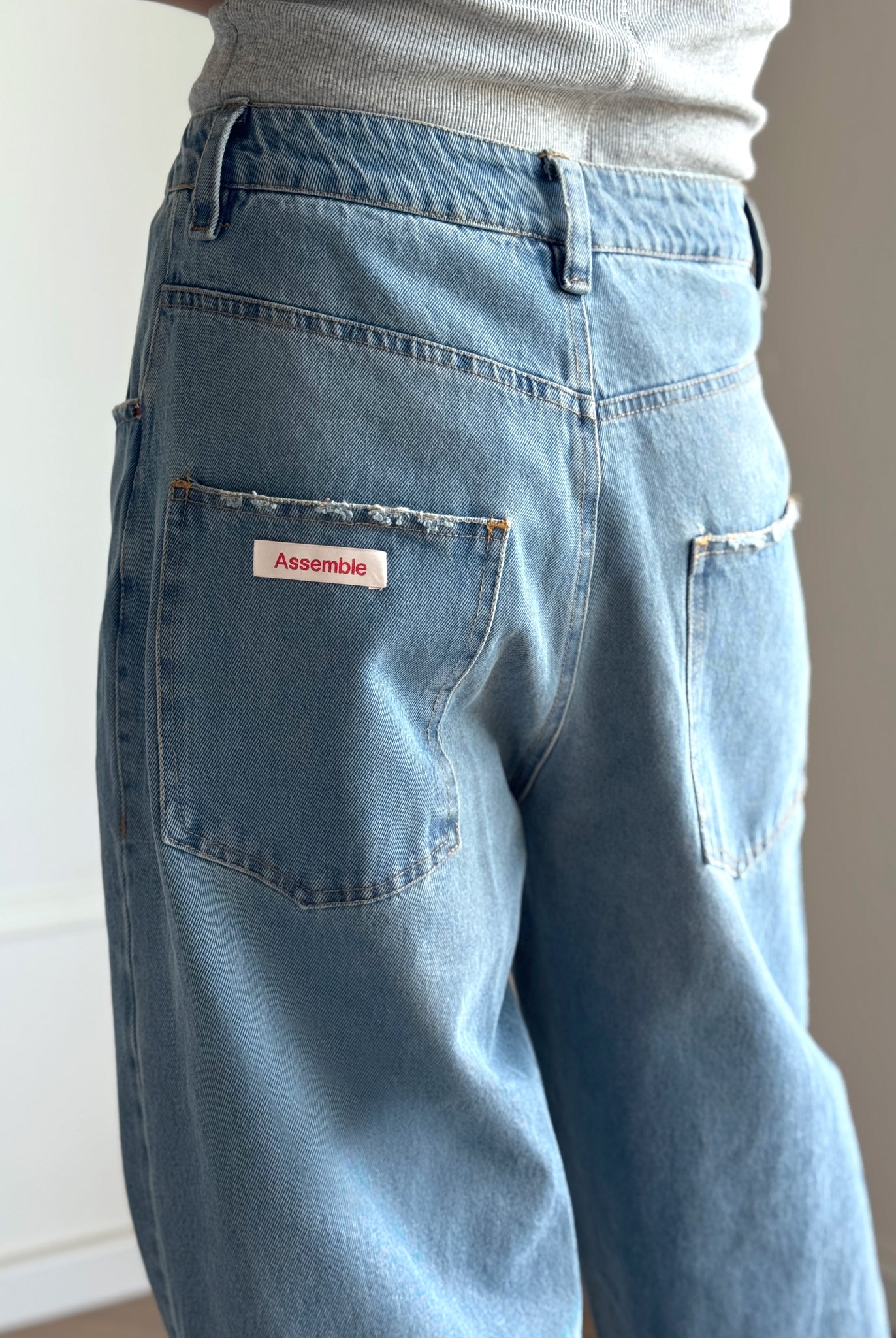 Assemble unisex denim twisted wide-leg jeans in light blue wash details
